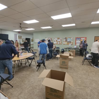Volunteers sorting donations and boxes in a community hall